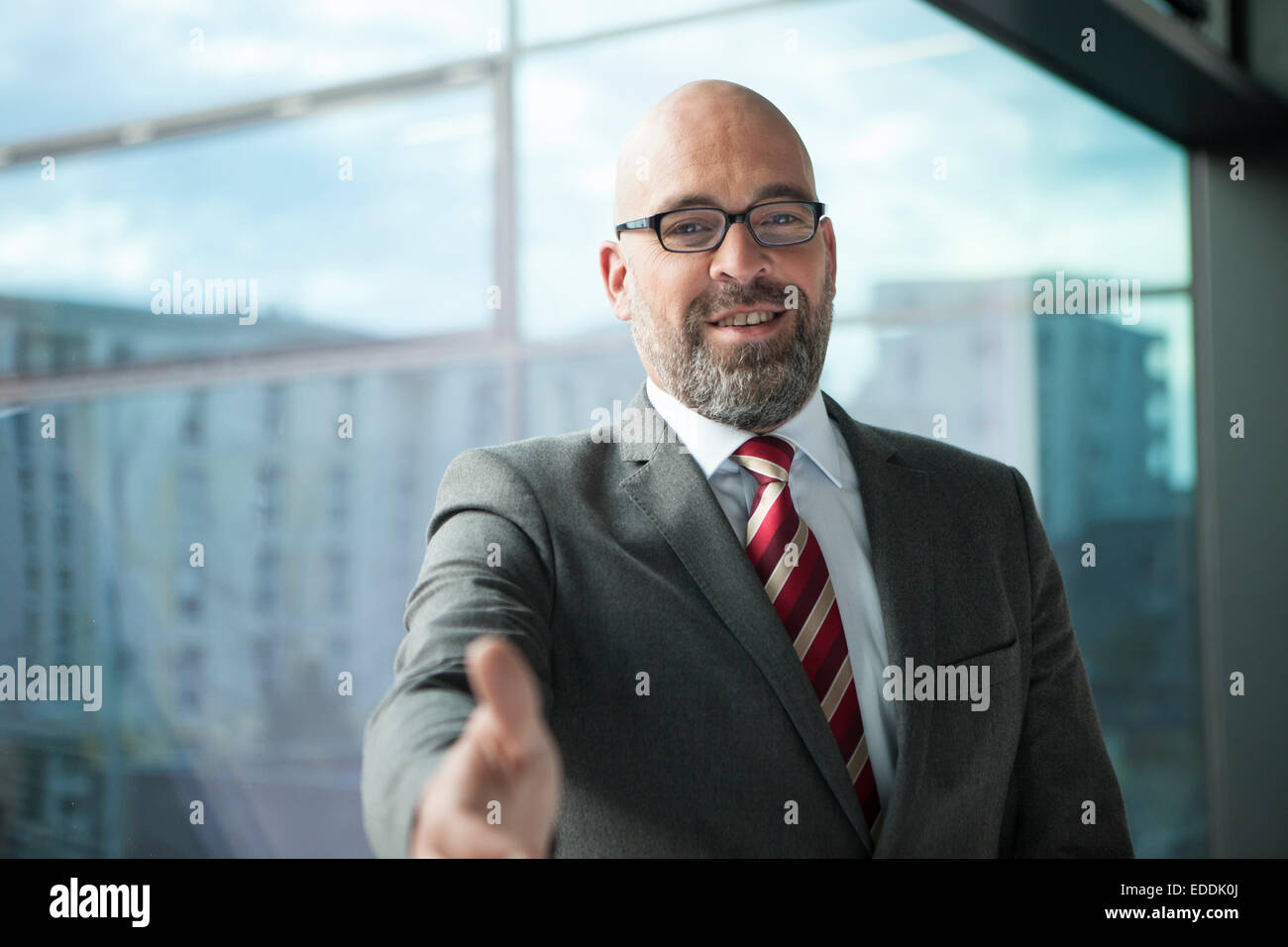 Geschäftsmann am Fenster seine Hand ausstrecken Stockfoto