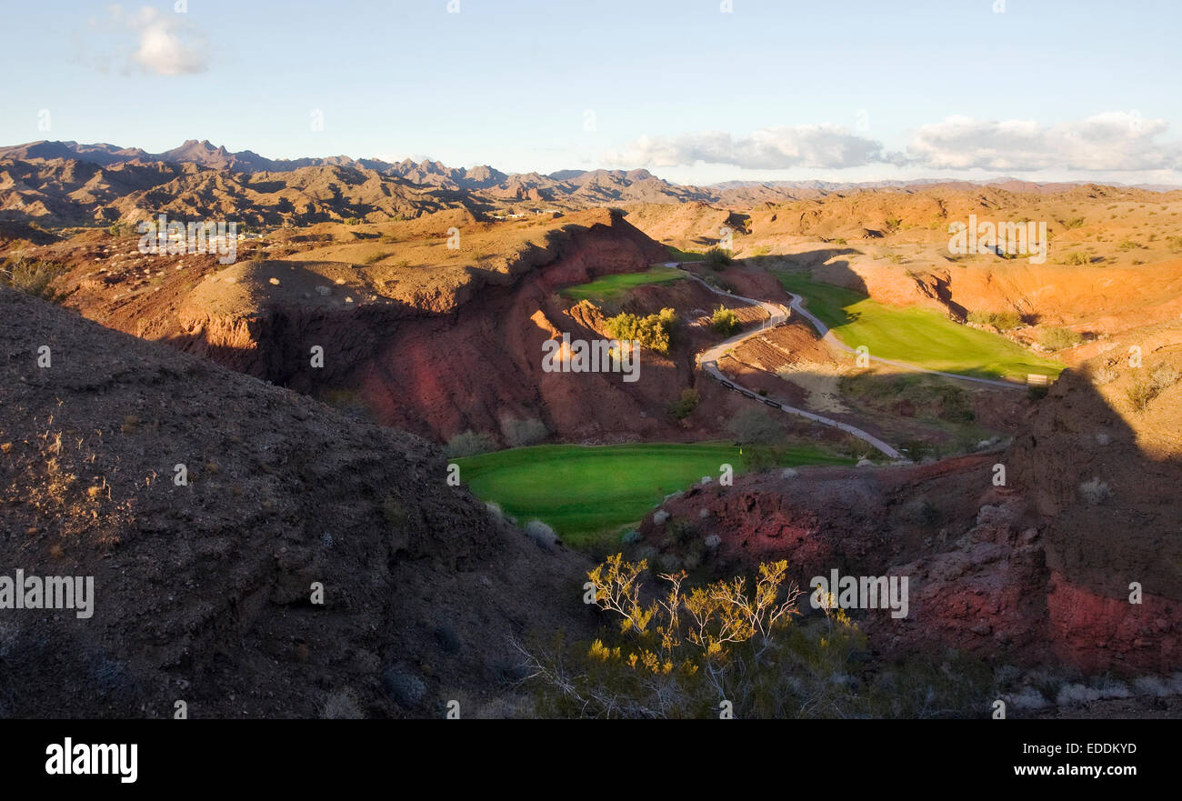 Einen erhöhten Blick auf die Berge und Wüste Landschaft und den Golfplatz Greens im Tal. Stockfoto