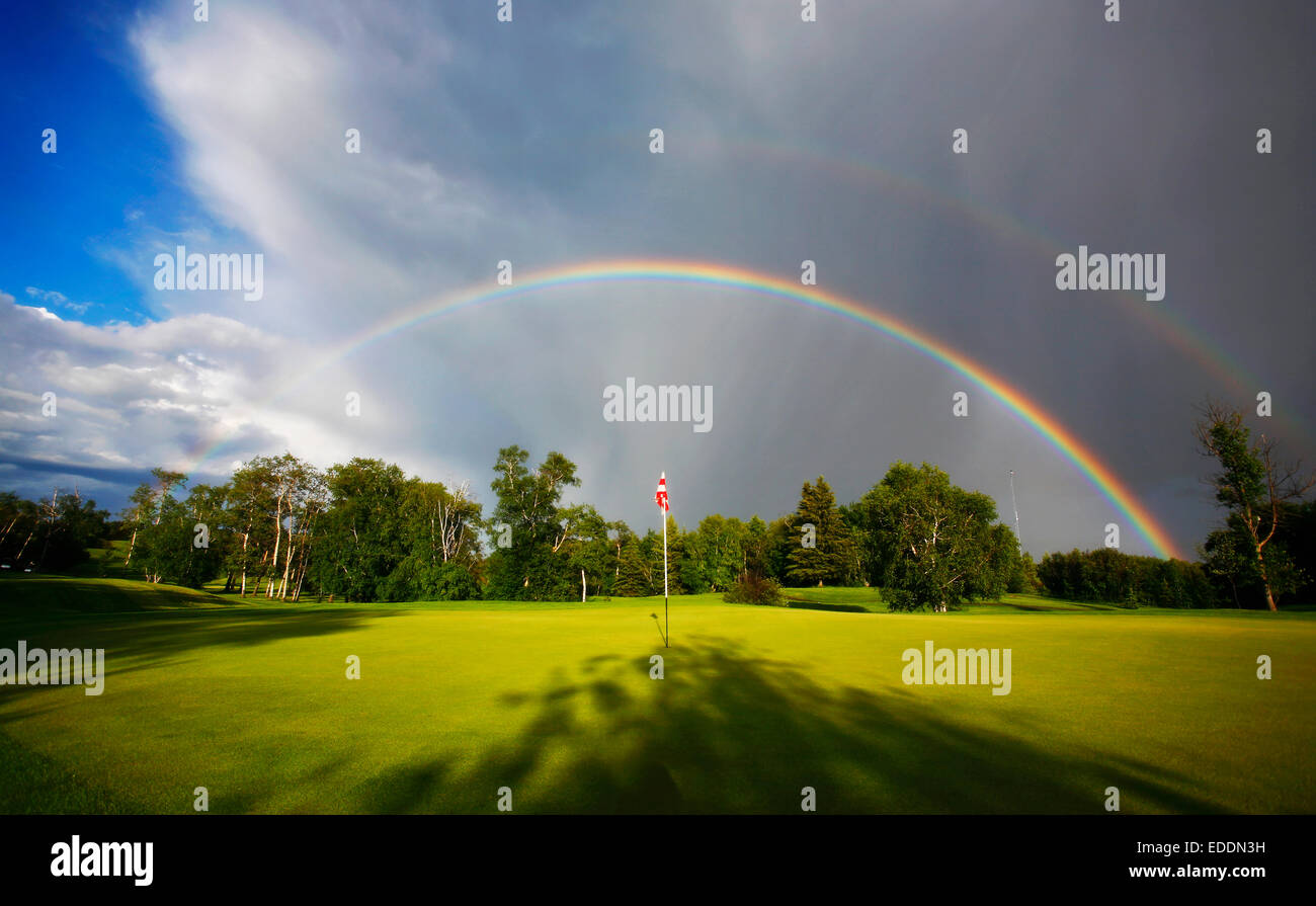 Ein Regenbogen am Himmel über einen Golfplatz. Stockfoto