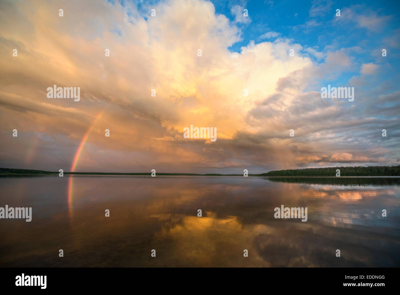 Ein Regenbogen und eine dramatische Wolkenformation über einen See. Stockfoto