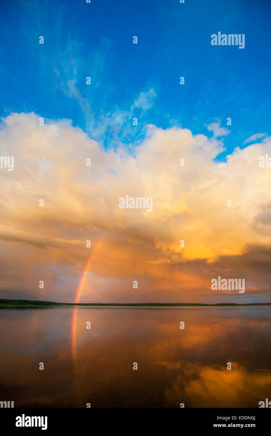 Ein Regenbogen und eine dramatische Wolkenformation über einen See. Stockfoto