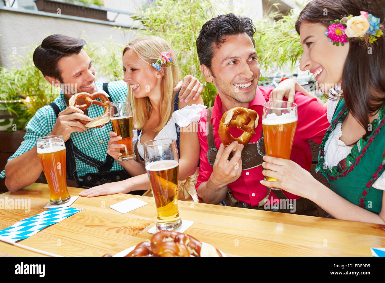 Männer und Frauen flirten im bayerischen Biergarten im Sommer Stockfoto