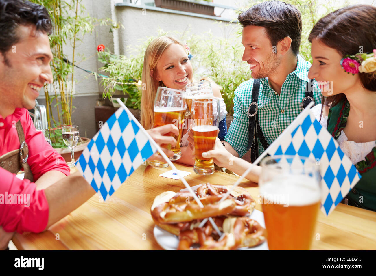 Lächelnde bayerischen Freunde Spaß im Biergarten in Deutschland Stockfoto