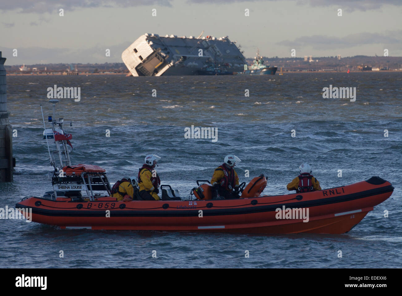 Cowes, Isle Of Wight. 6. Januar 2015. Das Leben geht auf in The Solent. Inshore RNLI-Rettungsboot steht. Gekenterten Autotransporter Hoegh Osaka in der späten Nachmittagssonne. Vermesser und Umfrage-Schiffe sind in Anwesenheit zur Bewertung des Zustandes des Schiffes und seiner Ladung. Windigem Wetter wird in den nächsten Tagen erwartet. Bildnachweis: Patrick Eden/Alamy Live-Nachrichten Stockfoto