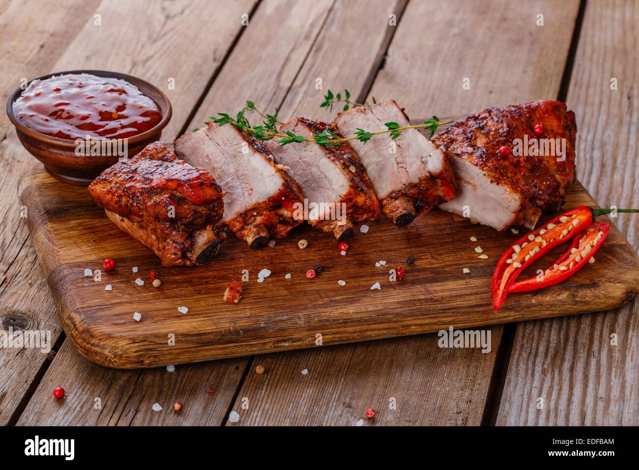 gebackene Schweinerippchen auf einem Holzbrett Stockfoto