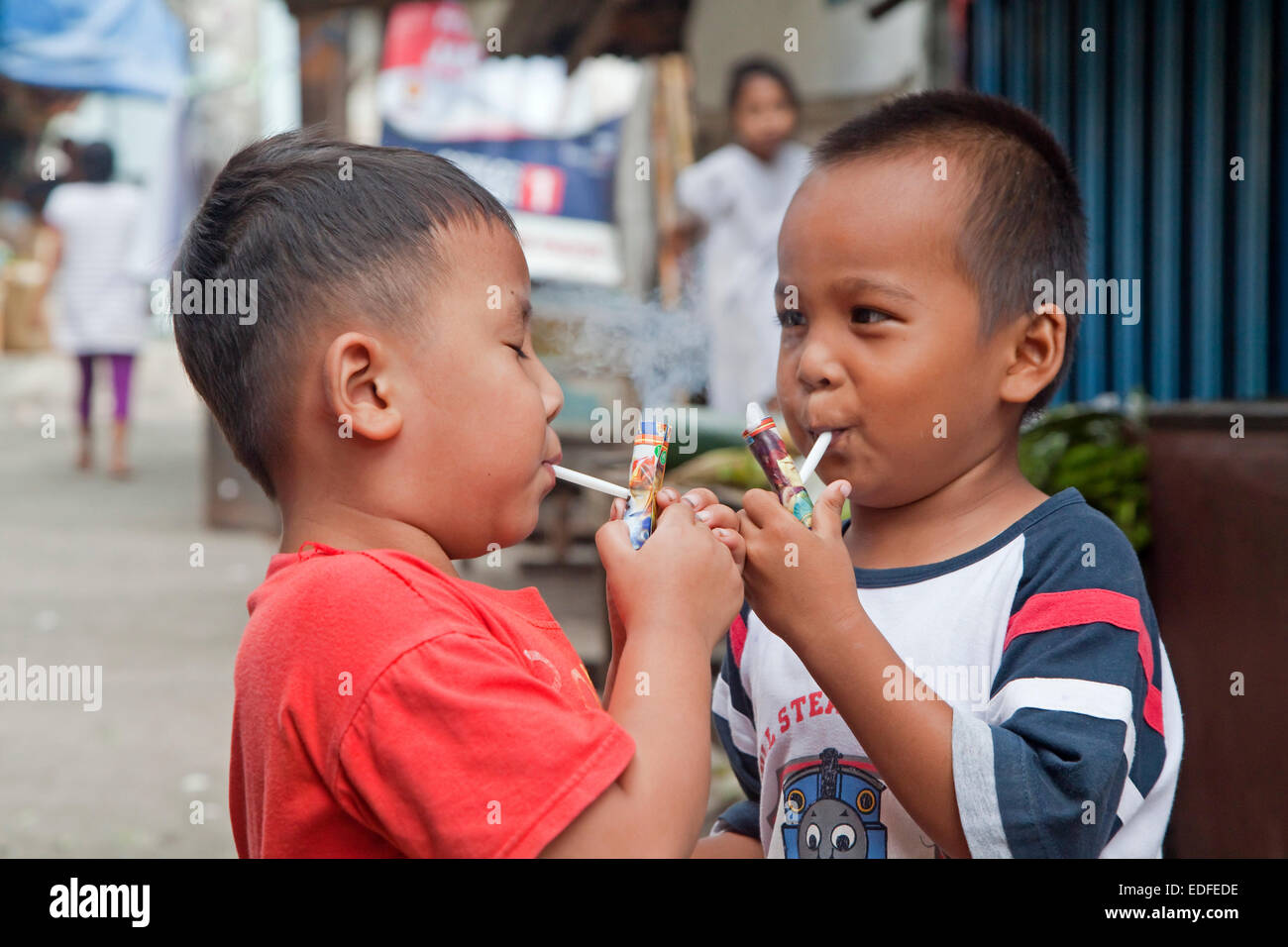 Indonesische Kinder gelehrt, wie man dadurch, dass Rauchen aufgefordert erlaubt entfernt auf hausgemachte Rohre Blätterteig Popeye Lauts, Indonesien Stockfoto