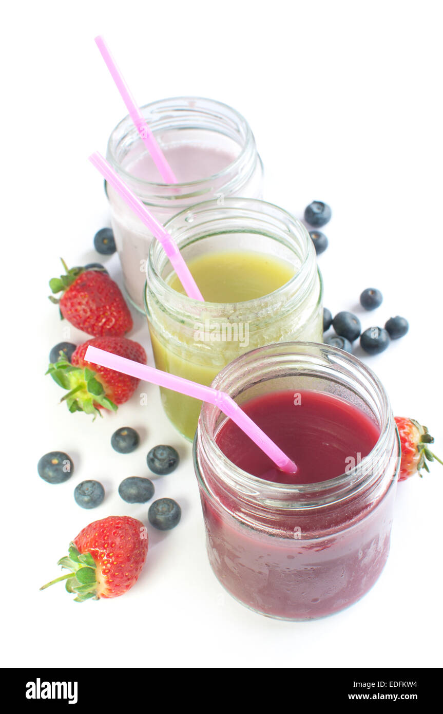Frucht-Smoothies in Gläsern über einen weißen Hintergrund mit Obst gekühlt Stockfoto