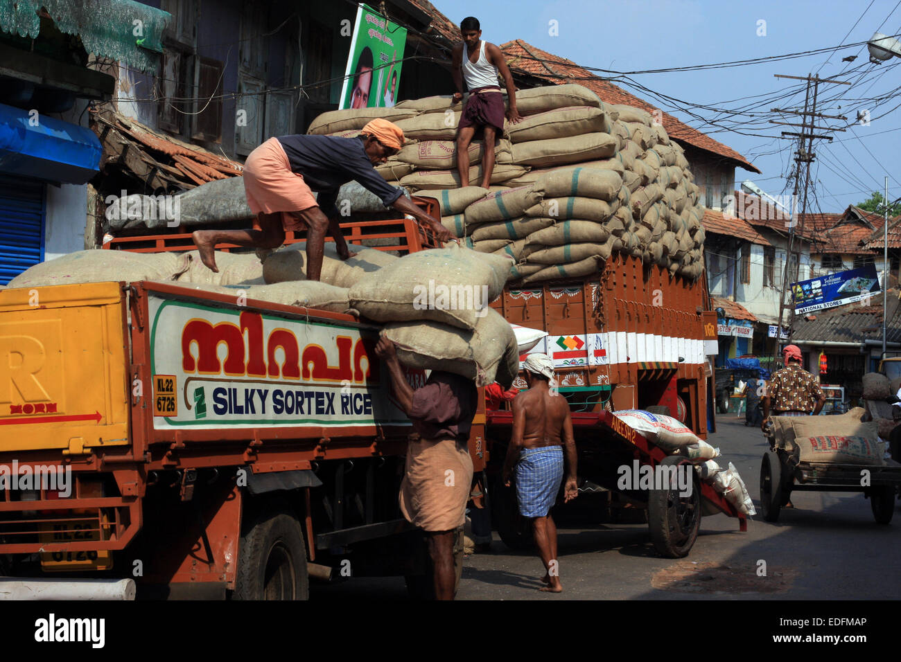 Männer laden einen LKW mit Säcke Reis auf Basar Road, Fort Cochin, Indien Stockfoto
