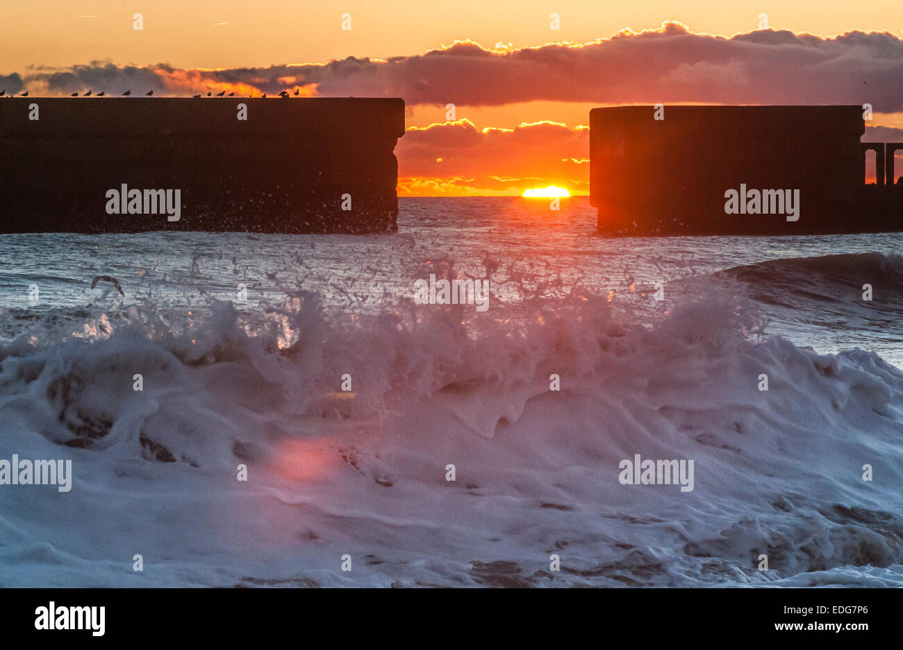 Hastings, East Sussex, Großbritannien. Januar 2015. Zweite Serie von Bildern, während die Sonne über den Strand und die Hafenmauer der Altstadt von Hastings untergeht. Ein hellerer Nachmittag und Abend nach starken Regenfällen und Wolken, die Temperatur beginnt mit Frost, der am Morgen erwartet wird Stockfoto