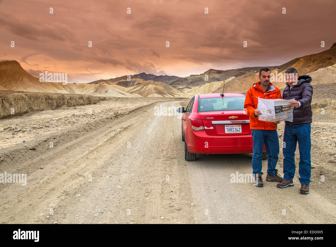 Zwei kaukasischen männlichen Touristen beobachten einen Fahrplan außerhalb ihrer Autos, Death Valley Nationalpark, Kalifornien, USA Stockfoto