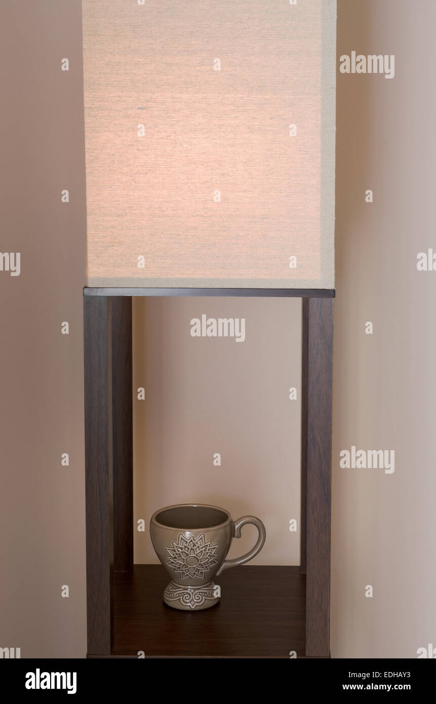 Stillleben mit Innendekorationen lichten Schatten und Cup am Regal Stockfoto
