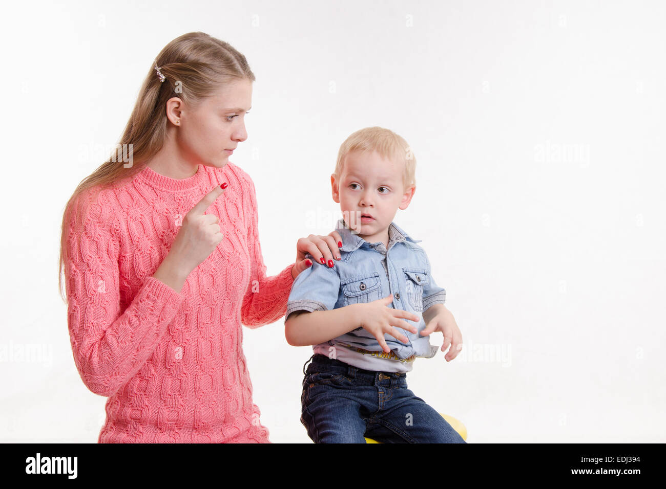 Junge schöne Mutter schimpft mit ihrem rebellischen und launisch drei Jahre alten Jungen Stockfoto