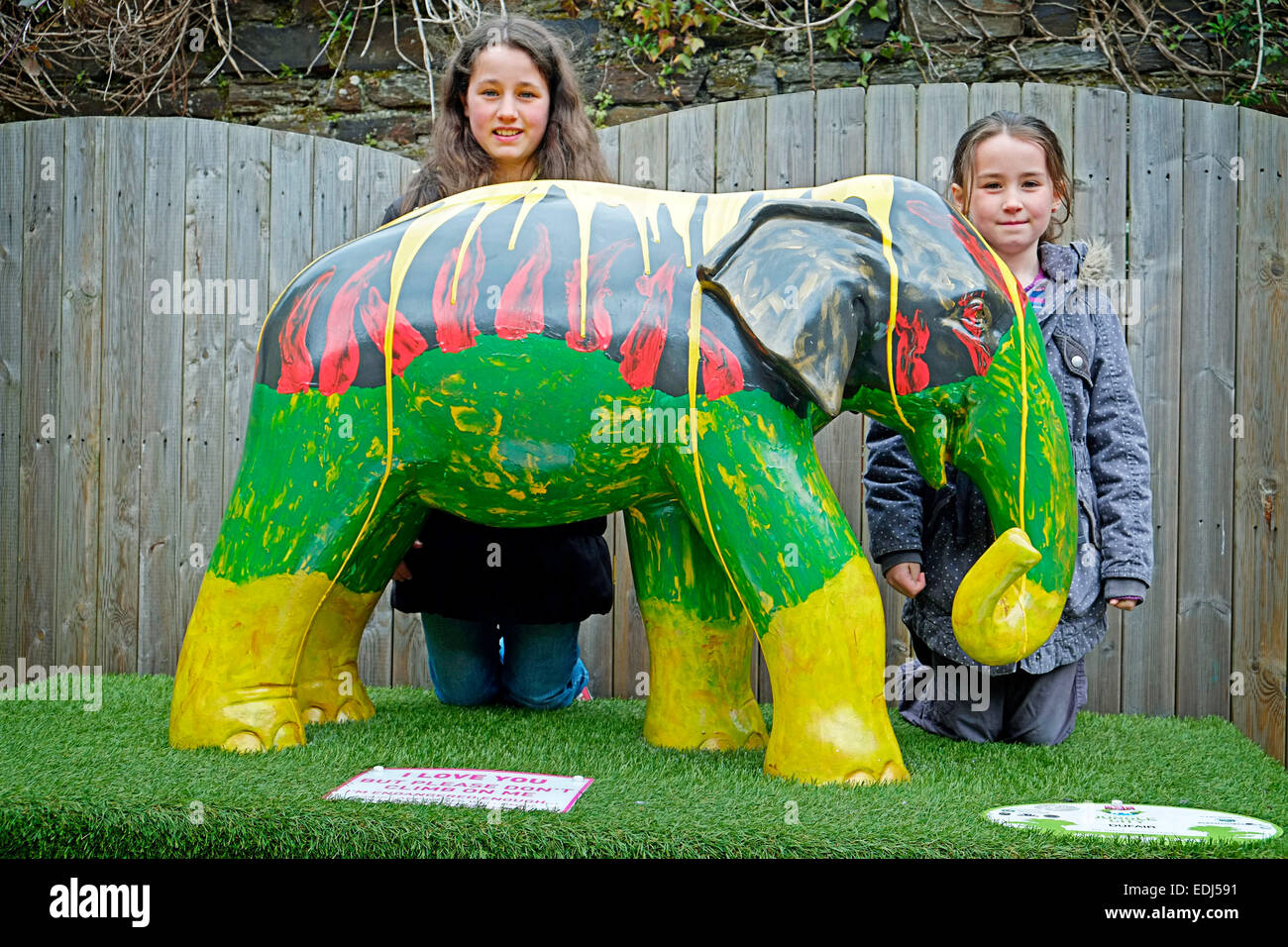 Zwei lächelnde Schulmädchen mit einem bunten Modell Elefanten in West Cork Clonakilty Stockfoto