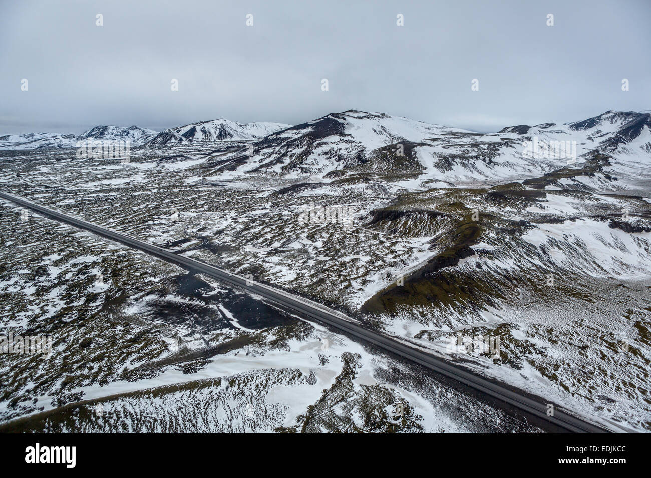 Leere Straße und leichten Schnee auf den Bergen, in der Nähe von Reykjavik, Island Stockfoto