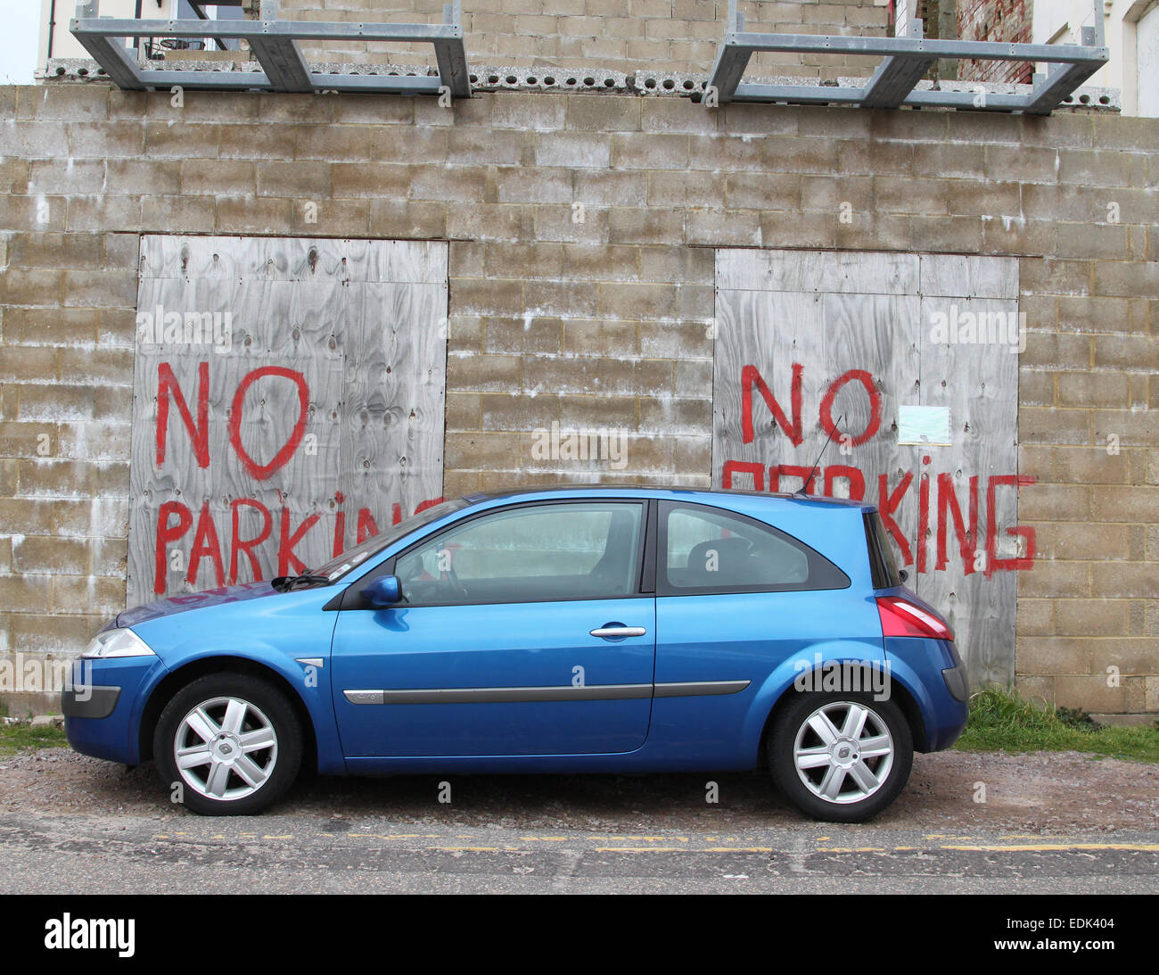 Auto geparkt vor "Parkverbot" gemalten Schild an Wand und boards Stockfoto