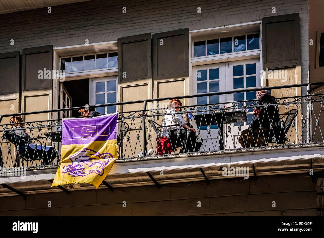 Leute sitzen auf dem Balkon blickte auf die Menschen unten auf der Bourbon Street in New Orleans LA Stockfoto