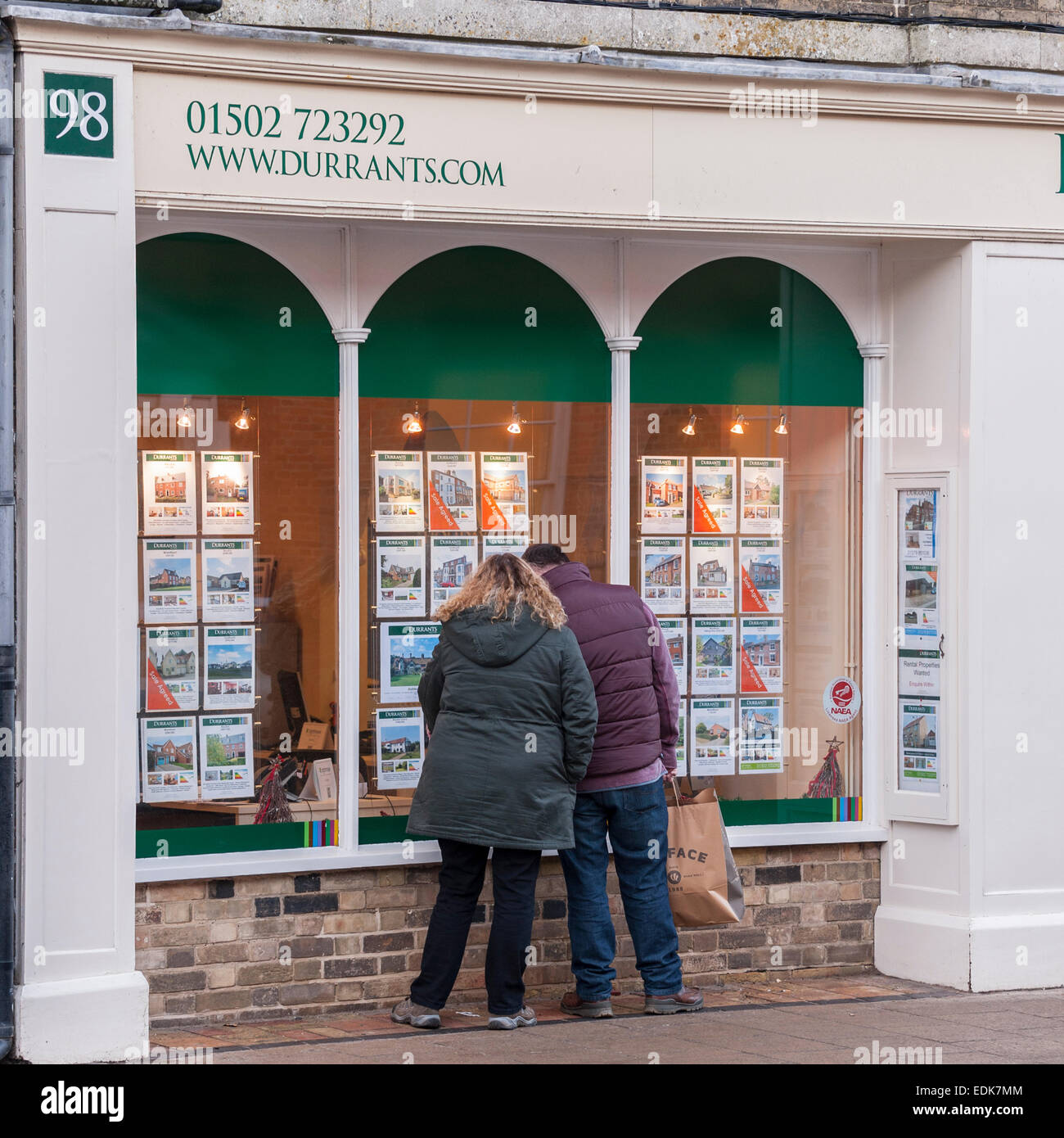Menschen suchen im Fenster Durrants Immobilienmakler in Southwold, Suffolk, England, Großbritannien, Uk Stockfoto