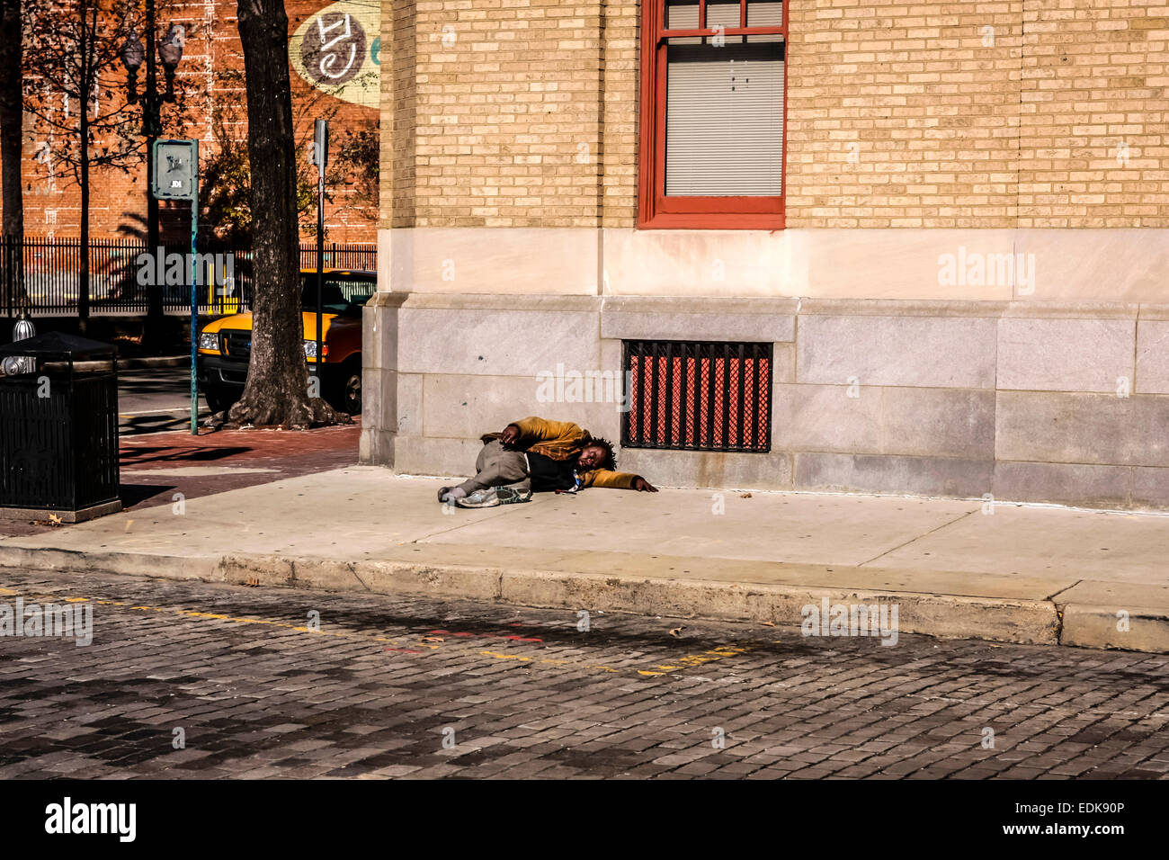 Schlafen auf dem Bürgersteig in einer ruhigen Straße in der Stadt New Orleans Louisiana Obdachlose Alkoholiker Stockfoto