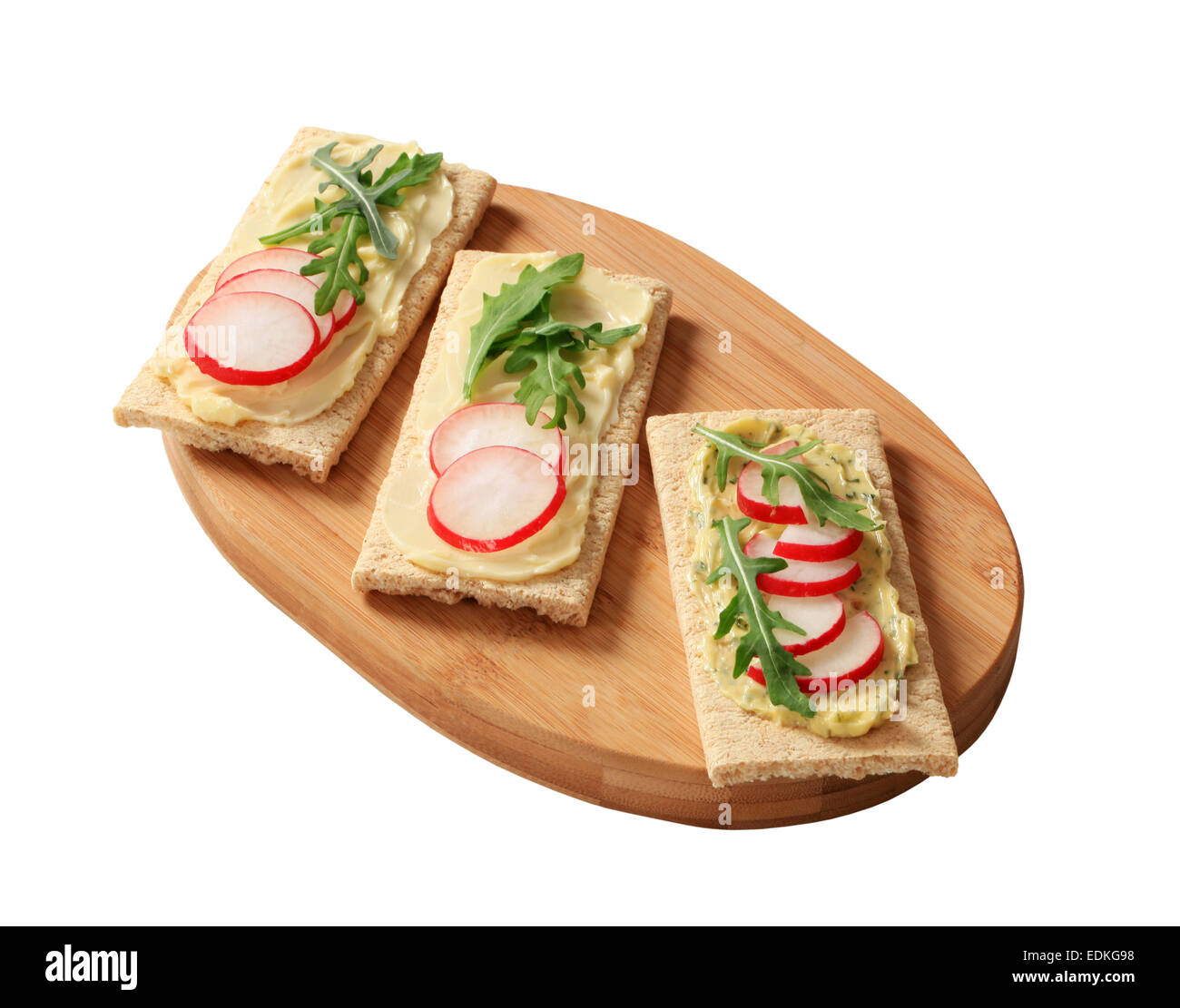 Knuspriges Brot mit Kräuterbutter, Radieschen und Rucola Stockfoto