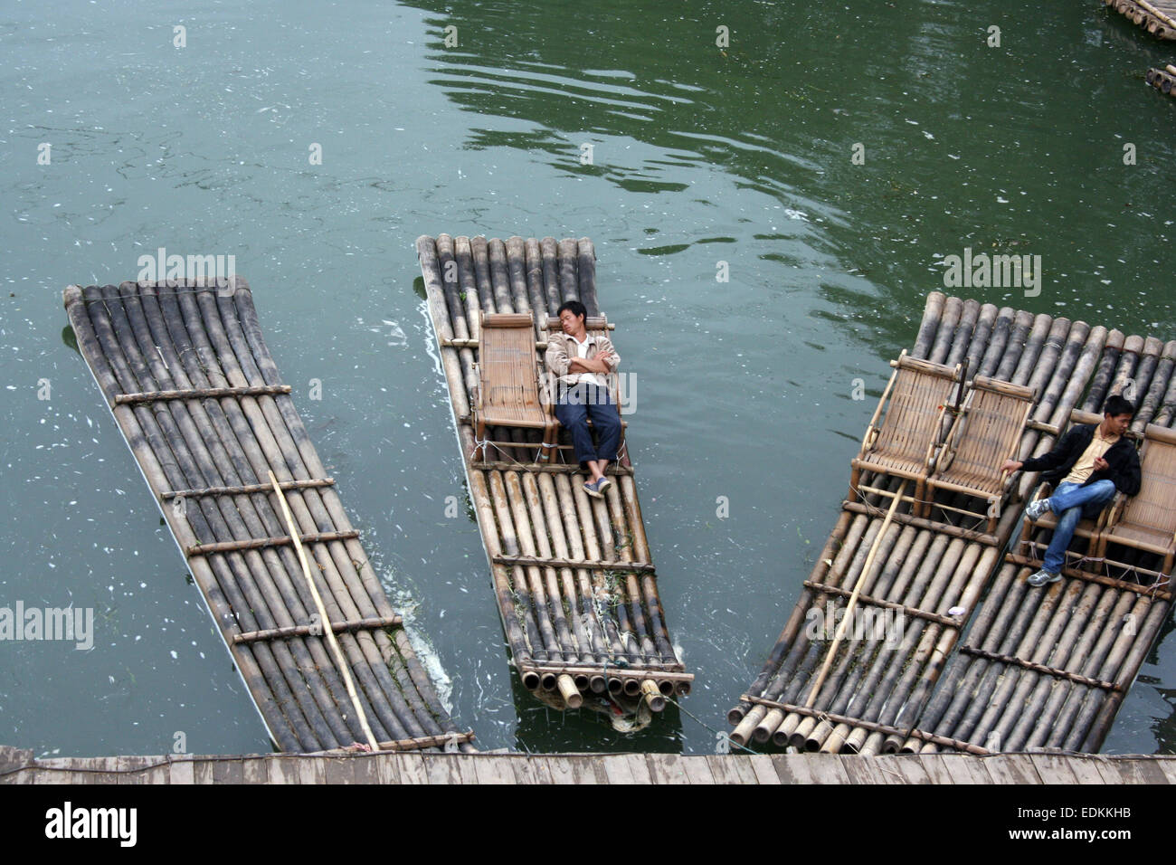 Zwei Männer entspannen auf Flößen auf dem Fluss Li durch die alten Dragon Bridge, in der Nähe von Yangshou, Südwest-China Stockfoto