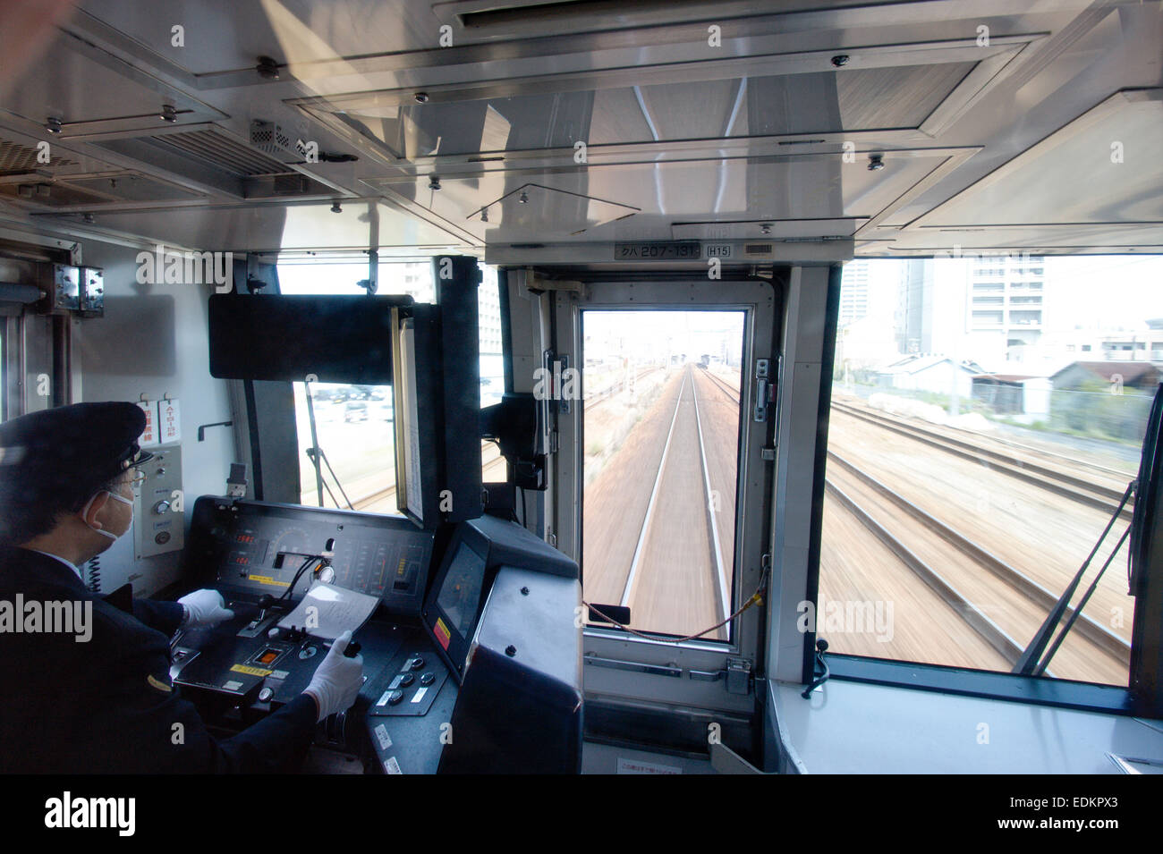 Innenansicht, vor dem japanischen Pendelzug Wagen Fahrer Taxi und der Blick draußen vor den Bahngleisen wie der Zug durch die Stadt beschleunigt. Stockfoto