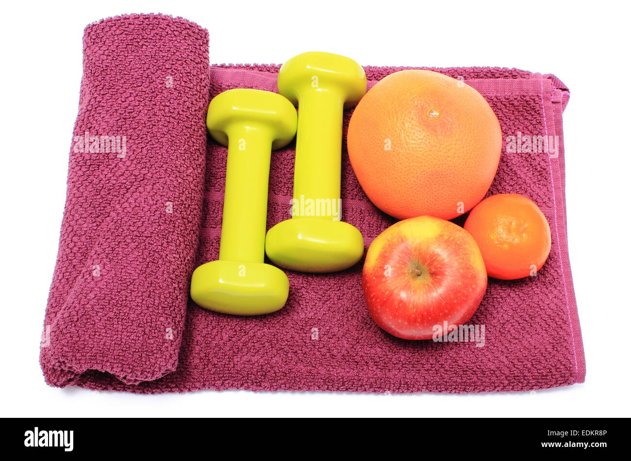 Frisches Obst und grünen Hanteln für den Einsatz in Fitness liegen auf lila Handtuch, Konzept für gesunde Ernährung und Lebensstil Stockfoto