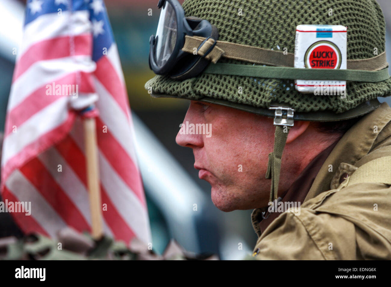 Ein Mann in Uniform eines amerikanischen Soldatenhelms mit Zigaretten Lucky Strike, Befreiungsfeiern, WW2 Helm Pilsen Tschechische Republik Stockfoto