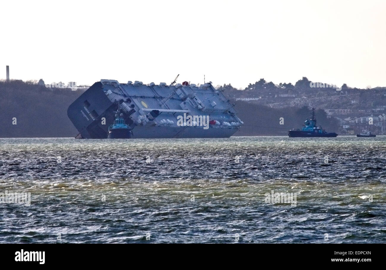 Solent, UK. 12:59 am 8. Januar 2015 - Hoegh Osaka Autotransporter von Cowes, gezogenen 2 Meilen von Bramble Bank in den Solent, wo sie am 3. Januar 2015, strandete, gewesen hat nun begonnen, um Schlepper, Störung der Schifffahrtsweg zu verhindern gedreht werden.  Der Schlepper auf der rechten Seite ist ein Seil verwenden, um das Schiff zu drehen, während die anderen Schlepper scheinen es stieß sein. Bildnachweis: Krys Bailey/Alamy Live-Nachrichten Stockfoto