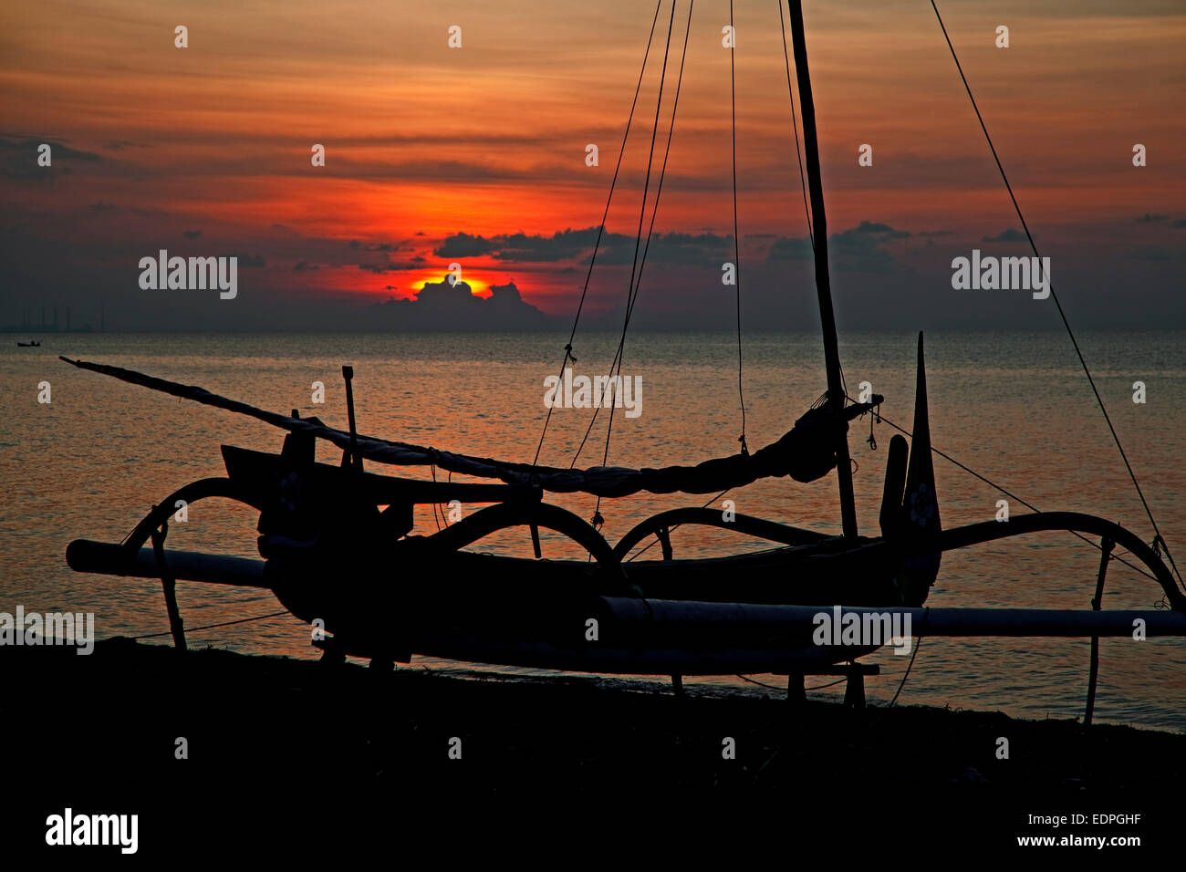 Silhouette javanischen Jukung, traditionellen hölzernen Ausleger-Kanu am Strand entlang des Indischen Ozeans bei Sonnenuntergang, West-Java, Indonesien Stockfoto