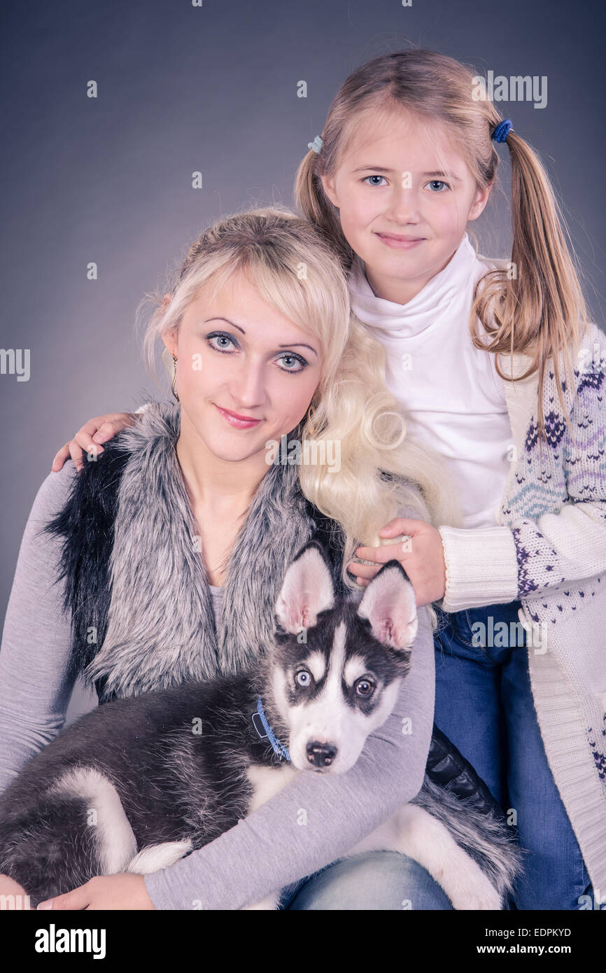 Studio-Porträt einer jungen Frau mit Tochter und einen husky Welpen Stockfoto