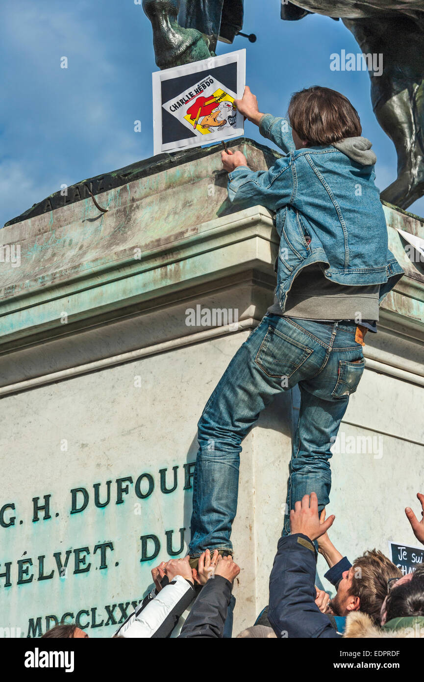 Genf, Schweiz. 8. Januar 2015. Ein Journalist, klettert auf eine Statue des Schweizer Held General Dufour ein Plakat während eine Mahnwache in Genfs Place de Neuve zur Solidarität mit den Opfern des Angriffs gegen Charlie Hebdo in Paris Credit setzen: Alistair Scott/Alamy Live News Stockfoto