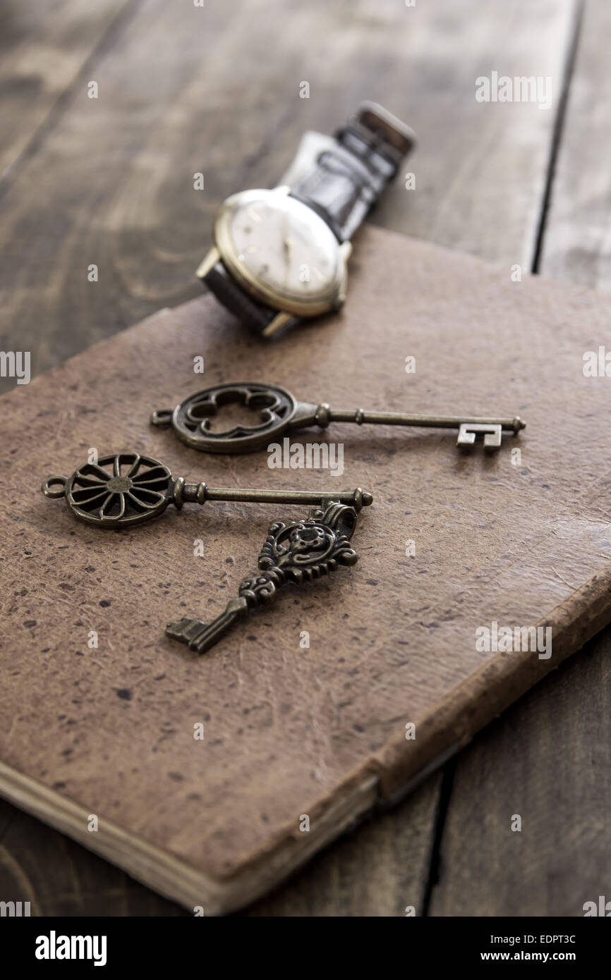 altes Buch und einen Messing-Schlüssel auf einem Vintage Oberfläche, Nahaufnahme Stockfoto
