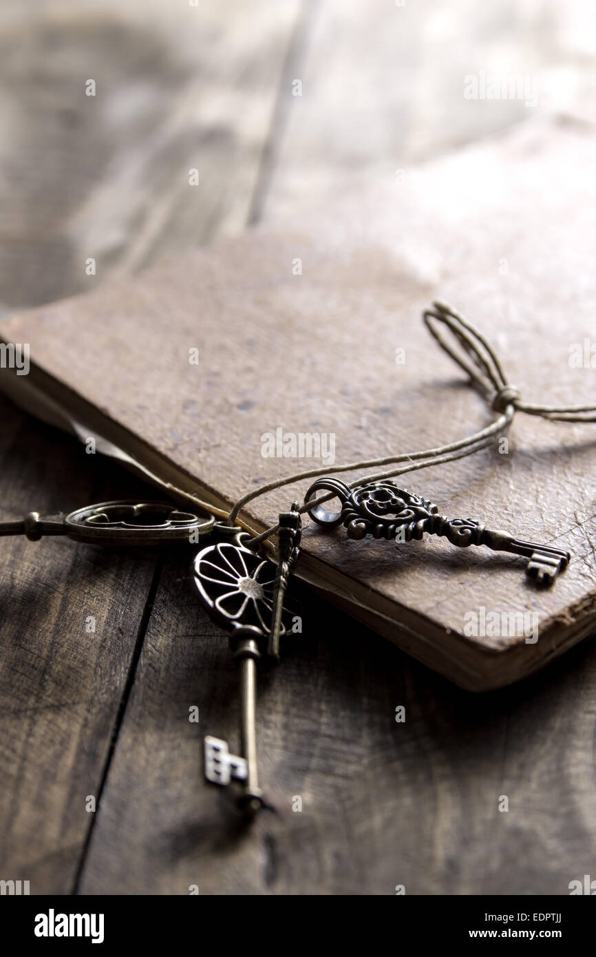altes Buch und einen Messing-Schlüssel auf einem Vintage Oberfläche, Nahaufnahme Stockfoto