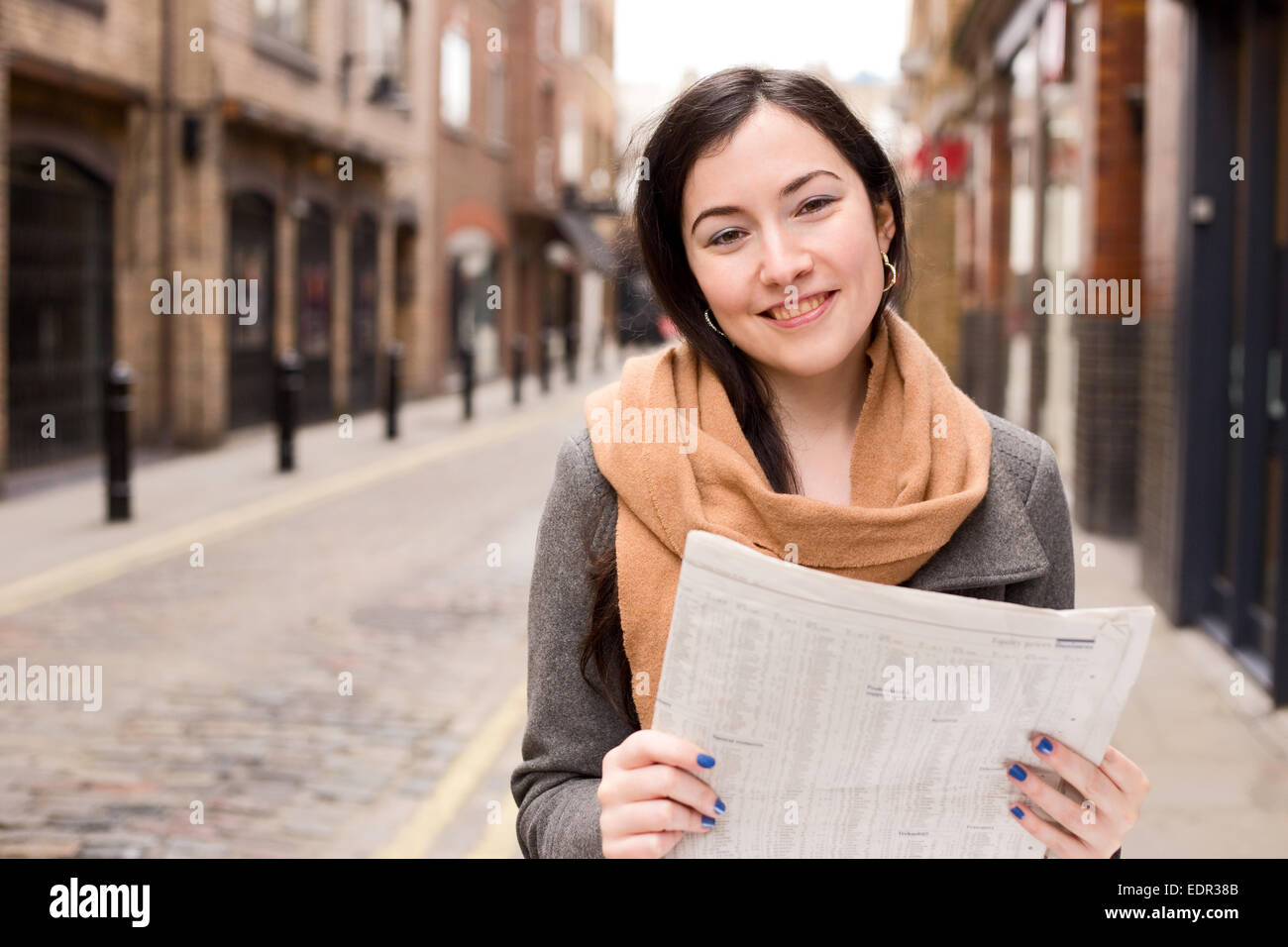 junge Frau, lesen eine Zeitung auf der Straße Stockfoto