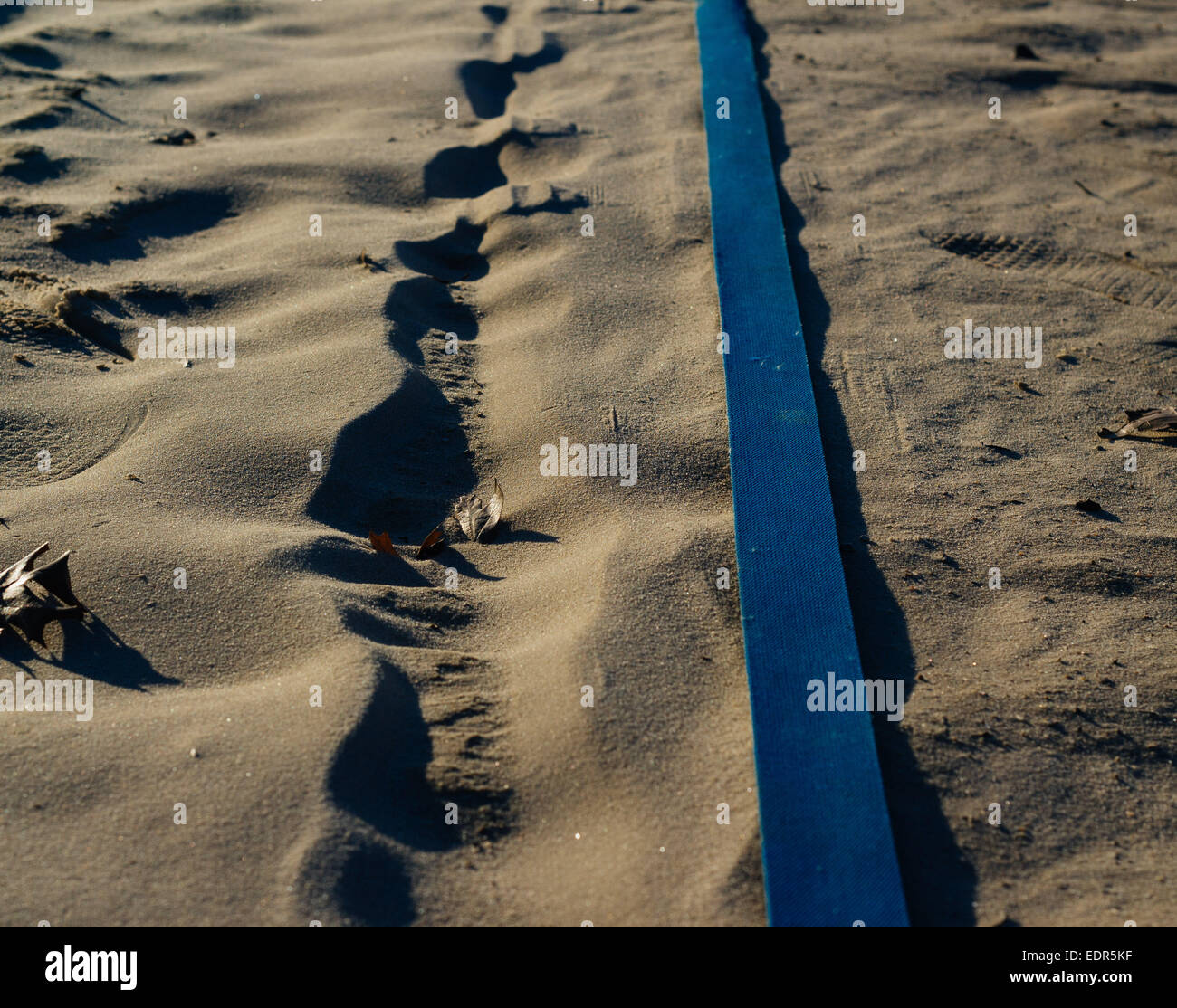 zwei parallele Linien, eine Sand und eine aus einem blauen Stoff Stockfoto