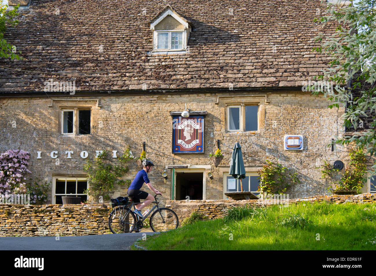 Radfahrer, Radfahren, vorbei an typischen englischen Pub The Victoria in das Dorf Eastleach Martin in Cotswolds, UK Stockfoto