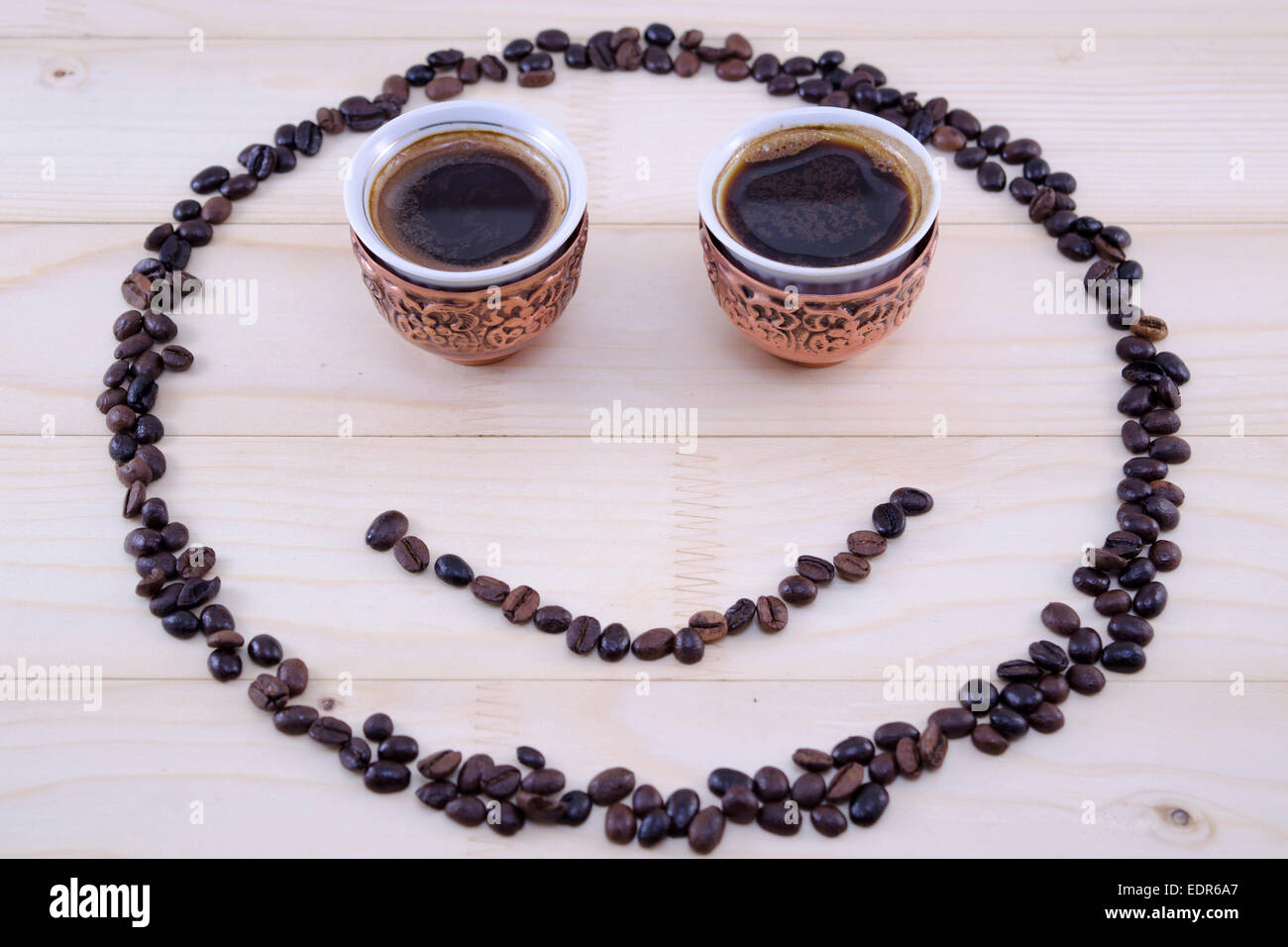 Smiley aus Kaffeekörner und zwei Vintage Tassen Kaffee als Augen gemacht Stockfoto