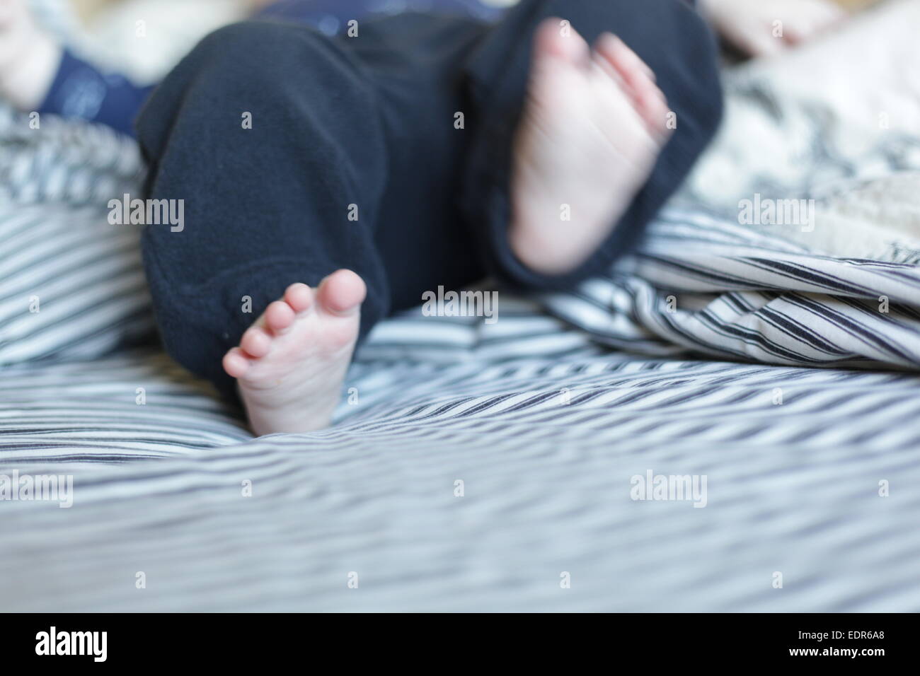 Baby Füße auf einem Bett Stockfoto