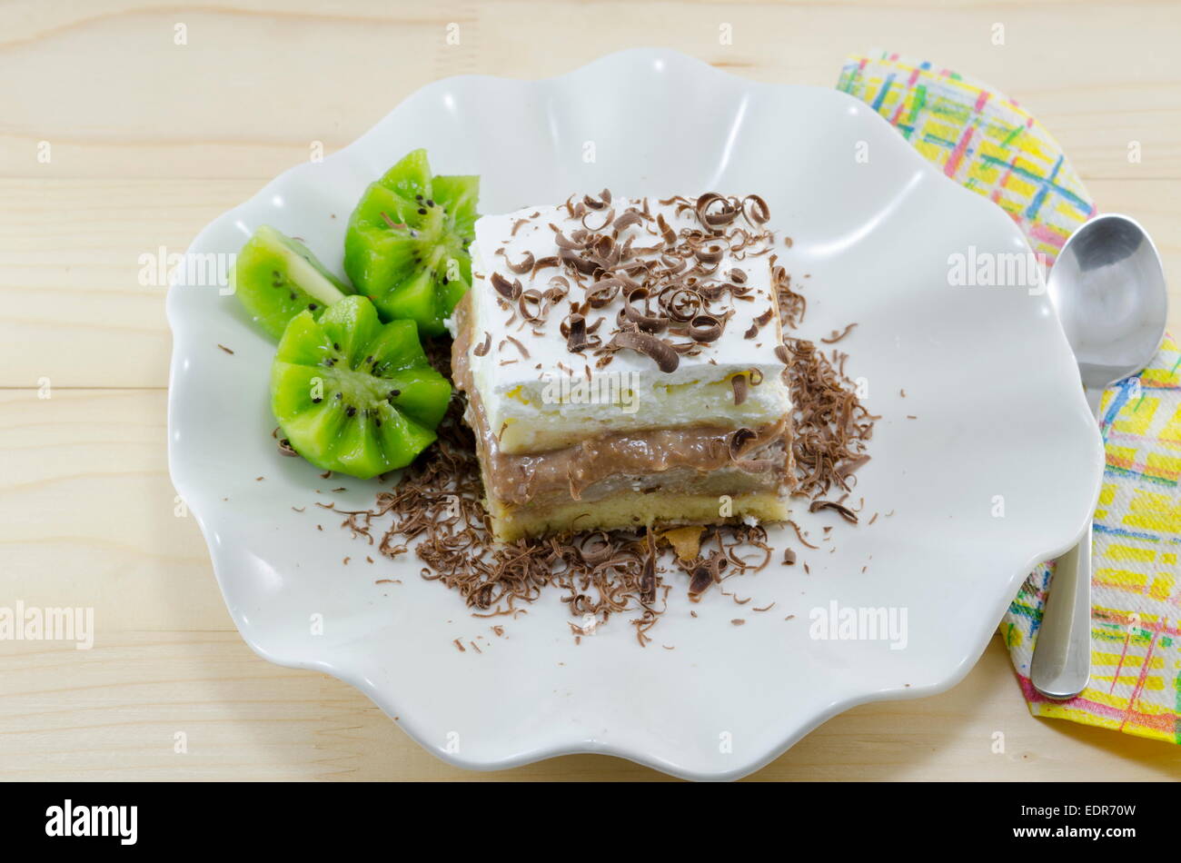 Ein Stück Kuchen mit Kiwi garniert auf einer Platte Stockfoto