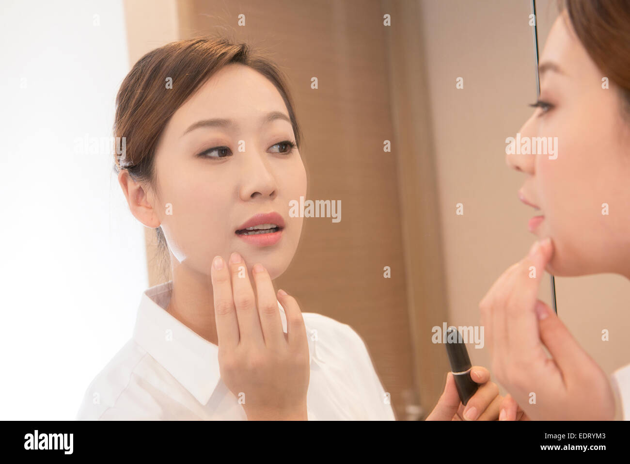 Junge Frau Make-up vor Spiegel überprüfen Stockfoto