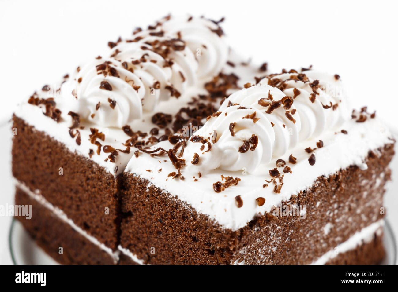 Schokoladekuchen mit weiße Creme obendrauf auf weißem Hintergrund Stockfoto