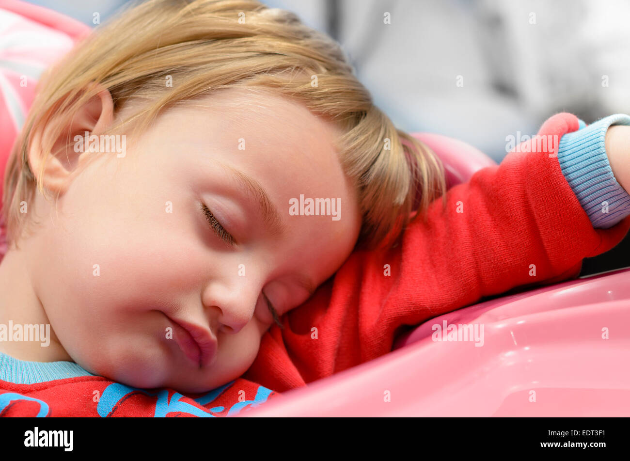 Niedliche Babyjungen schlafen in einem Hochstuhl Stockfoto