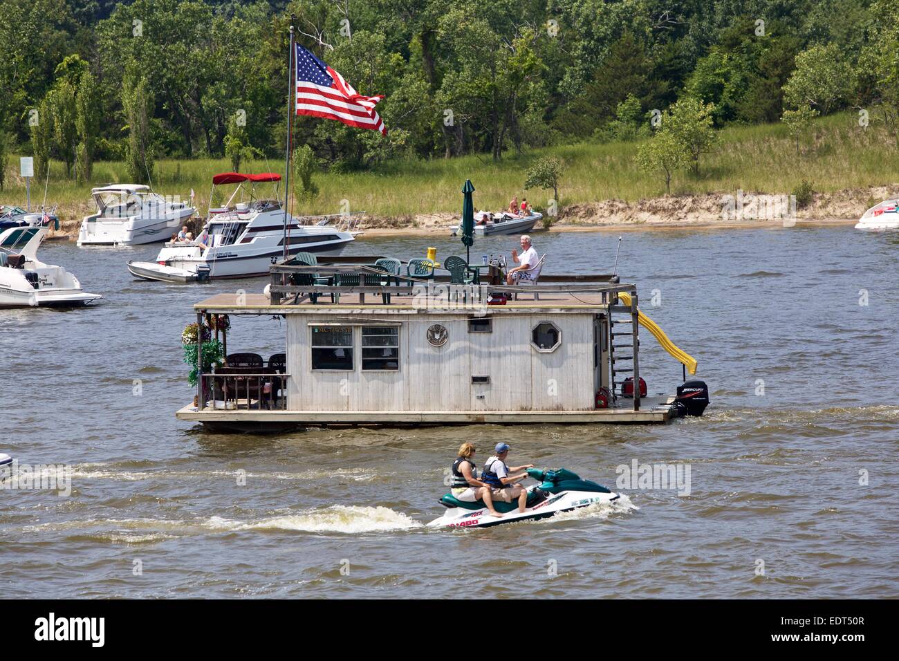 Man steuert ein Vintage Hausboot auf dem Grand River im Grand Haven, Michigan während des Festivals der Coast Guard Stockfoto