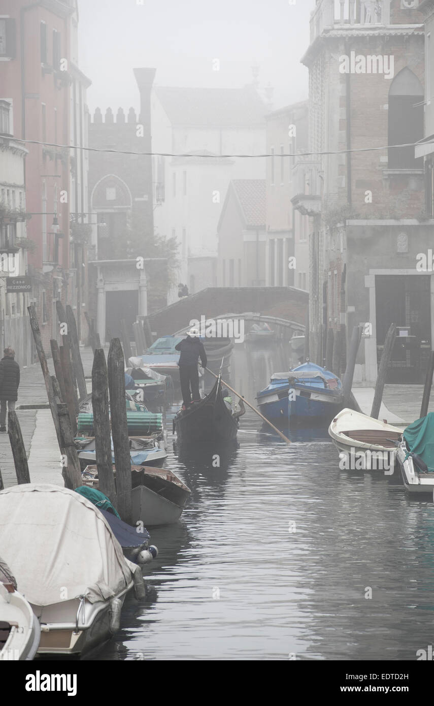 Winter in Venedig - eine Gondel Kreuzfahrt auf einem Kanal im Nebel. Stockfoto