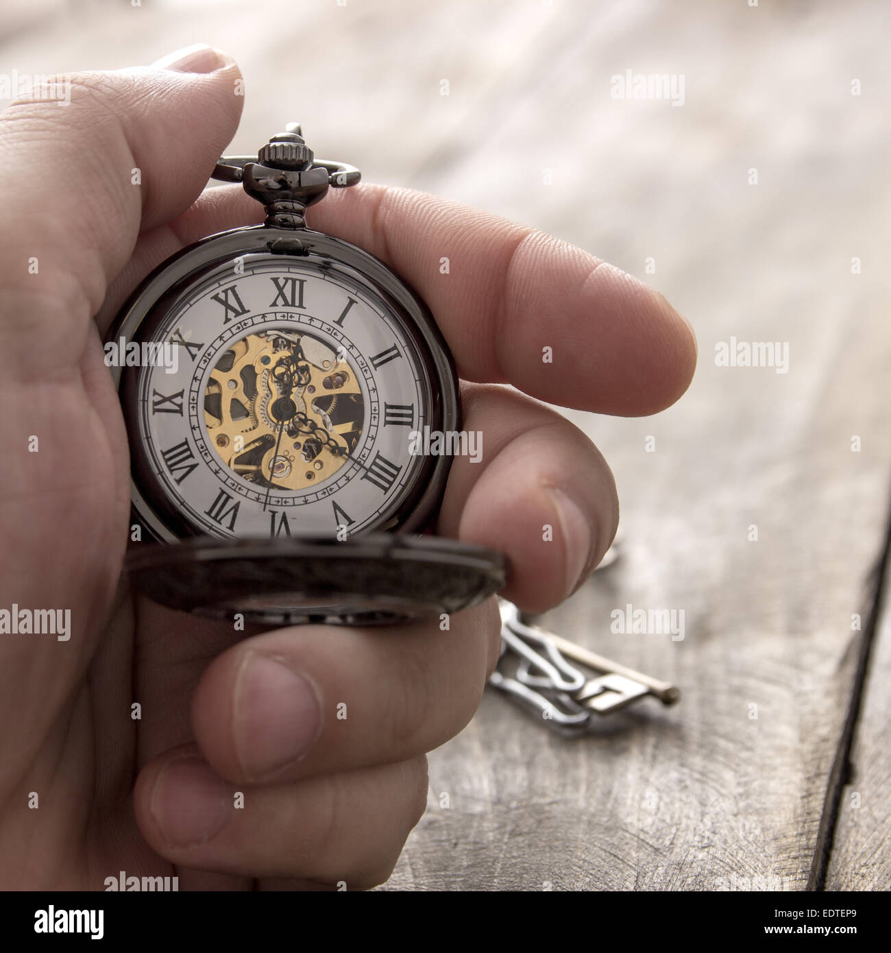 Nahaufnahme der Hände mit Vintage Taschenuhr über hölzerne Hintergrund Stockfoto