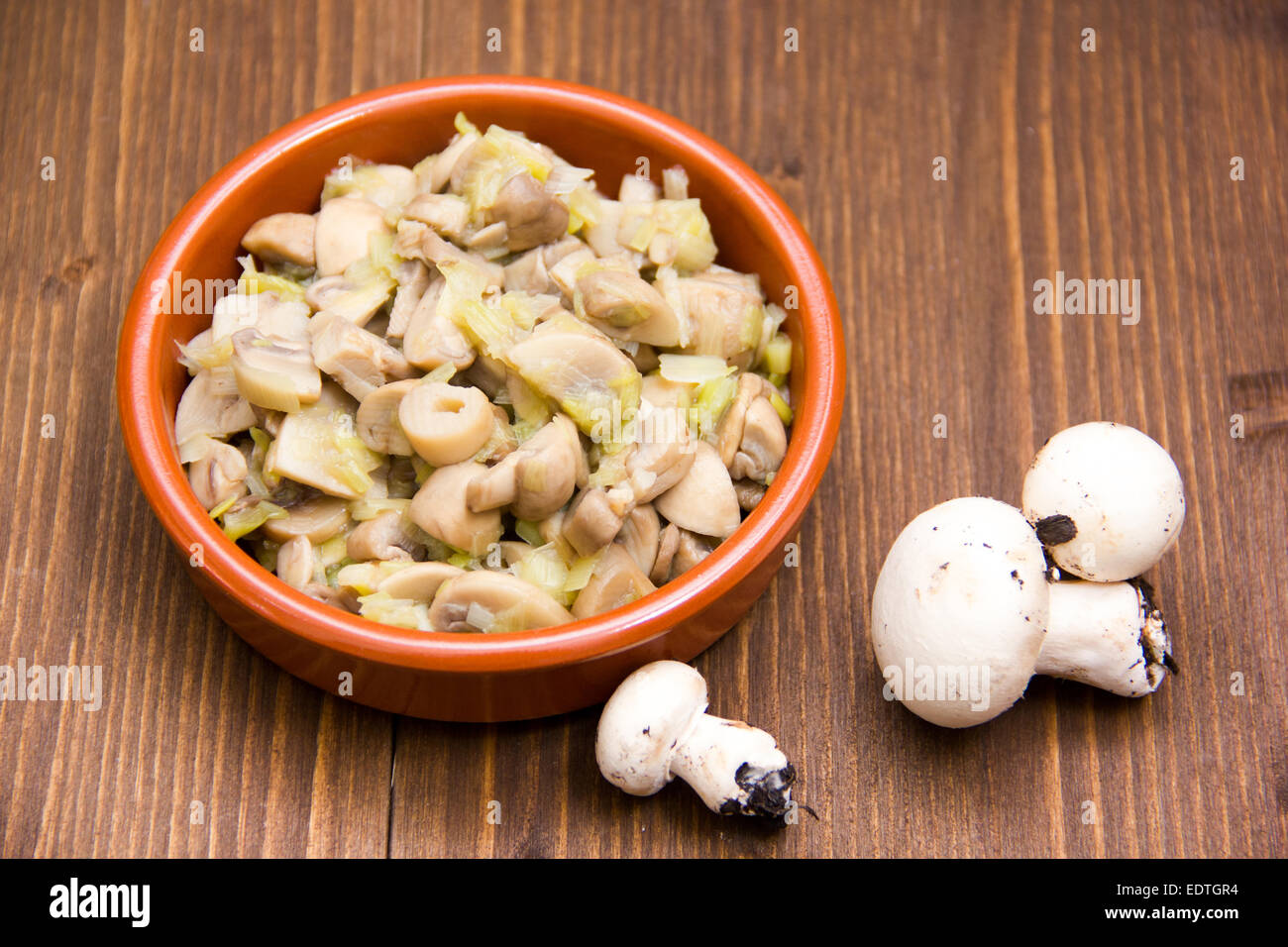 Gegrillte Champignons auf Schüssel auf Holztisch Stockfoto