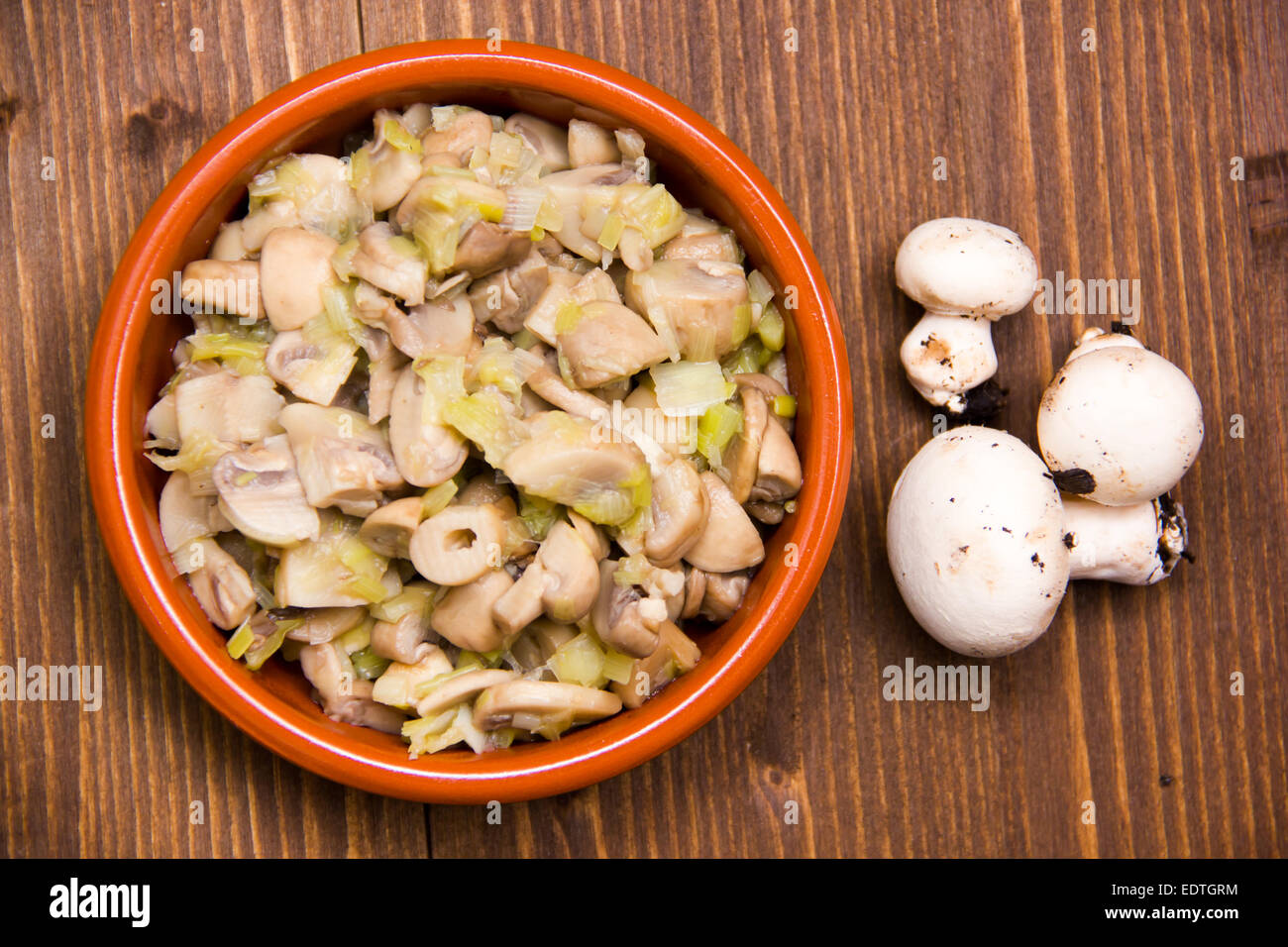 Gegrillte Champignons auf Schüssel auf Holztisch von oben gesehen Stockfoto