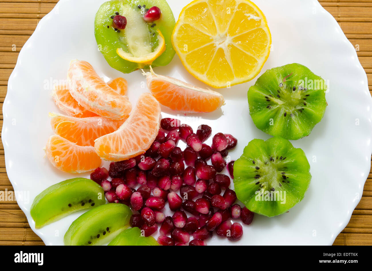 In Scheiben geschnittenen Orangen, Zitronen, Kiwis und Granatapfel auf einem Teller Stockfoto