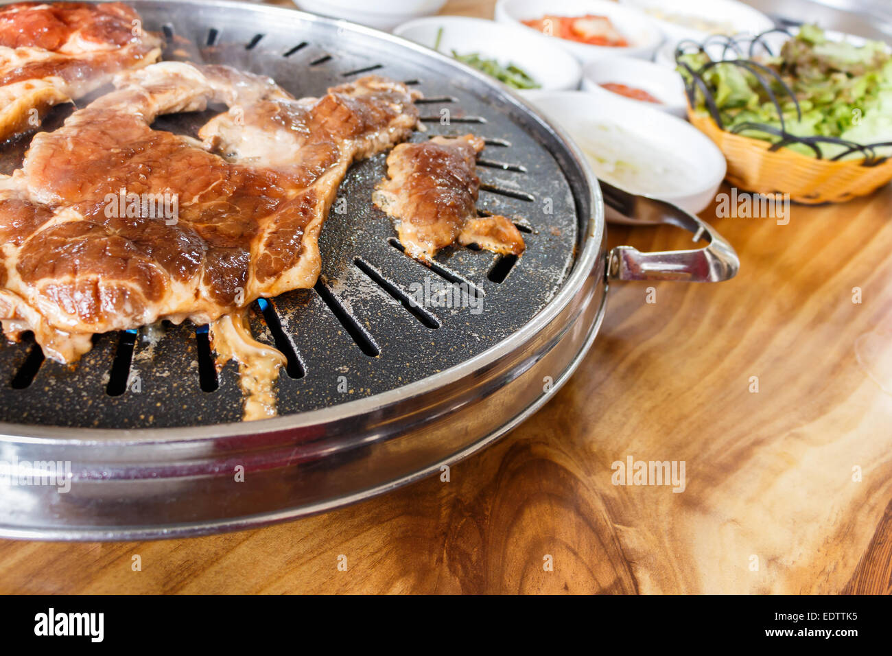 Fleisch war Braten auf Röster, Gemüse und Gewürze auf Holztisch Stockfoto