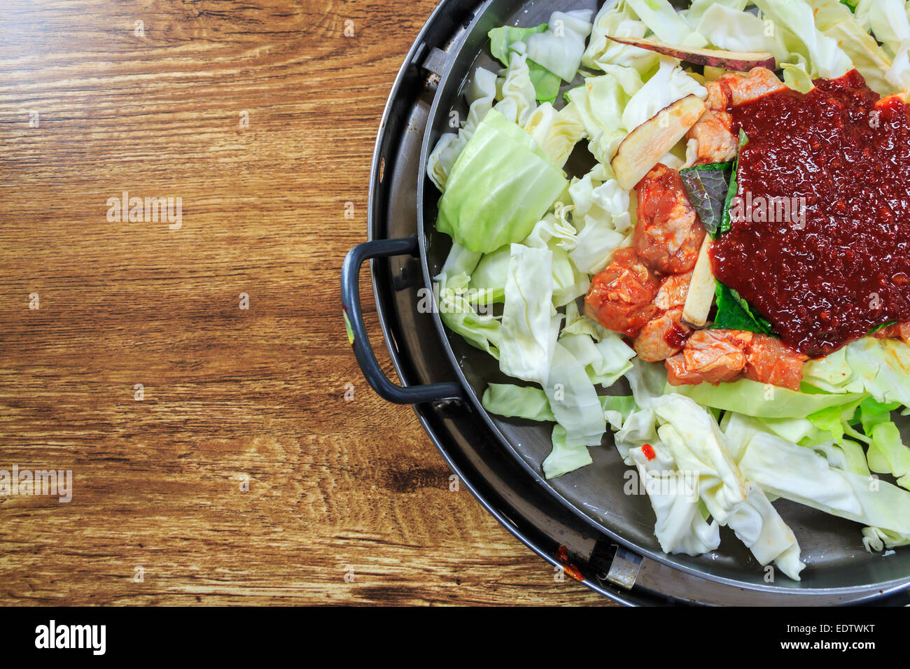 Würze des koreanisches Essen auf Pfanne zu komponieren, frischem Salat, Huhn, Ketchup auf Holztisch mit leeren Bereich auf der linken Seite Stockfoto